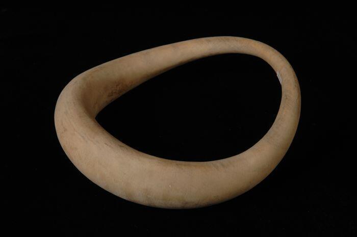 Hoedenmal in de vorm van gebogen bolle ring met een brede en een smalle zijde van naturelkleurig…