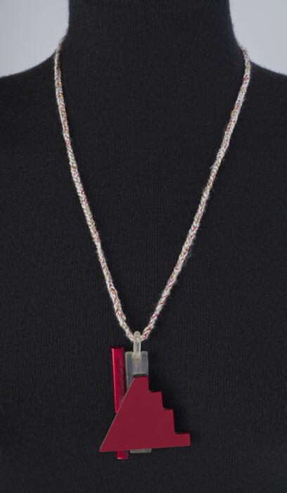 Driehoekige rode kunststofen hanger aan gehaakt koord van wit en rood garen gemeleerd met zilver en…