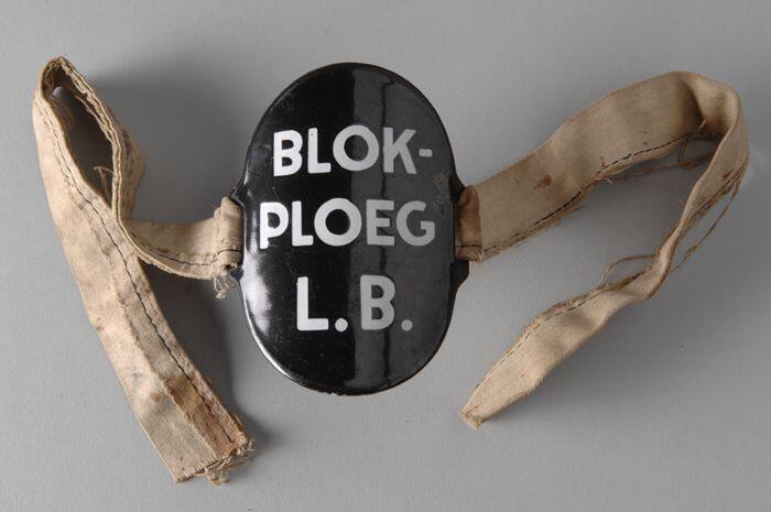 Ovaal zwart geëmailleerd armschildje met "BLOK-PLOEG L.B." aan (hergebruikte) band met "11682"