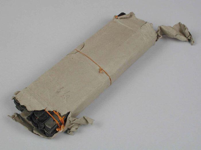 Pakket met een gros halflange platte donkerbruine baleinen, gebundeld in dozijnen met drie oranje…