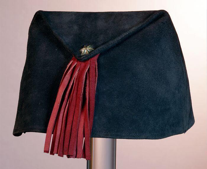 Dameshoed, trapeziumvormig zwart suede met flap, gevouwen naar een zijde vastgezet met stervormige…