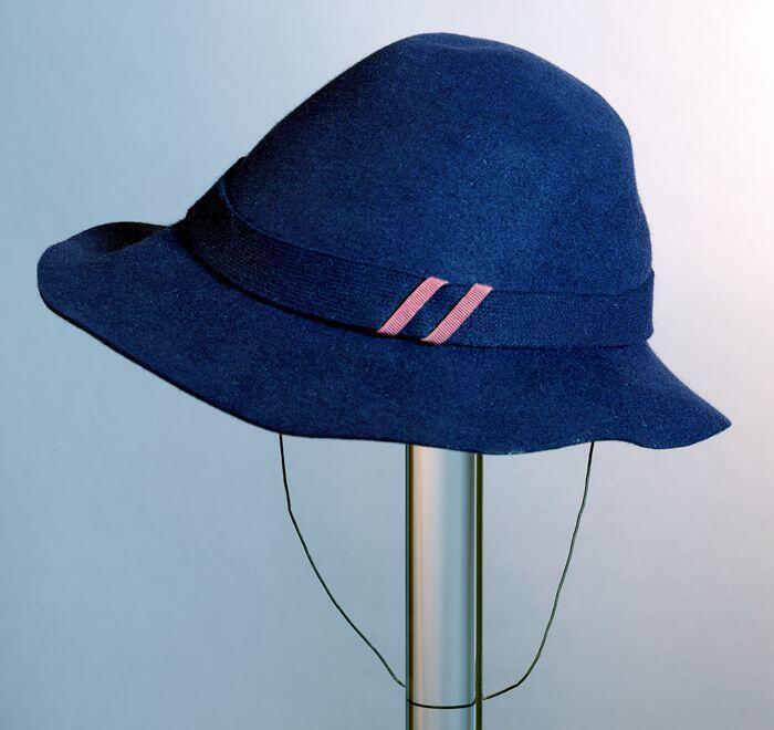 Ronde cloche van donkerblauw vilt met slappe rand, doorgestikt viltband met garnering van rood…