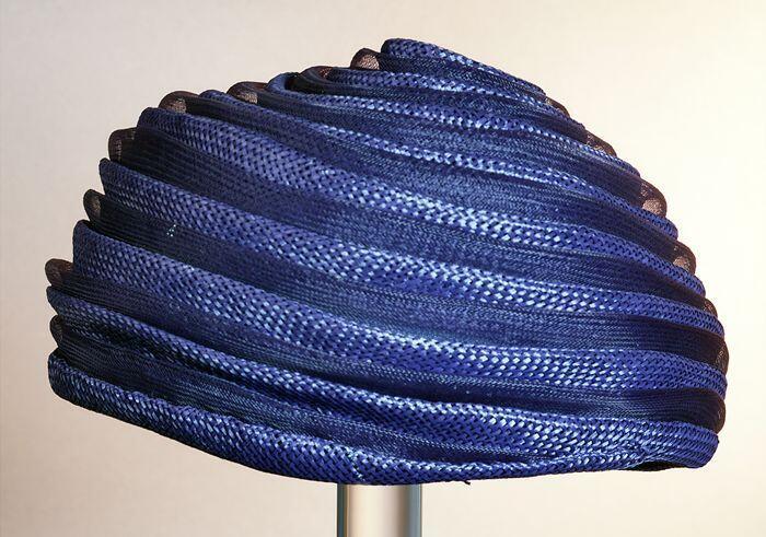 Ronde donkerblauwe dameshoed zonder rand, spiraalvormige opbouw van banen gaas en stro, raffiaen…