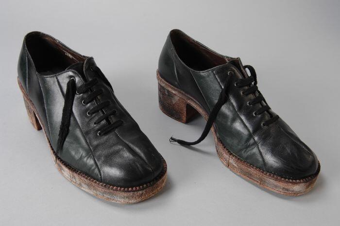 Zwart en groen leren herenschoenen met vetersluiting en bruine kunststofplateauzool, om en om een…