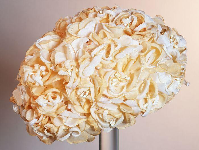 Dameshoed, rond zonder rand, oppervlak bedekt met kunststoforanje witte bloemen