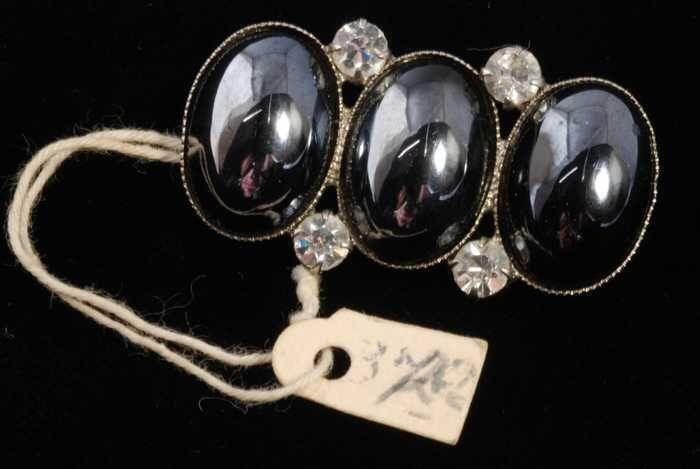 Broche, drie ovale bolle hematiet (?) stenen met kunstdiamantjes in een zilverkleurige metalen…