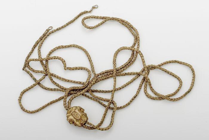 Gouden ketting met knopje in vorm van wapen