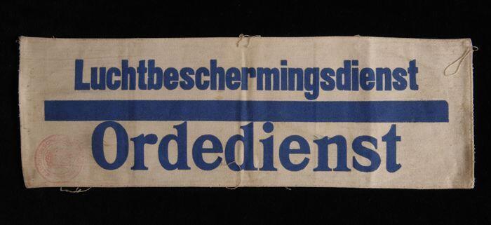 Mouwband, wit keperkatoen met opdruk in donkerblauw, "Luchtbeschermingsdienst Ordedienst", rode…