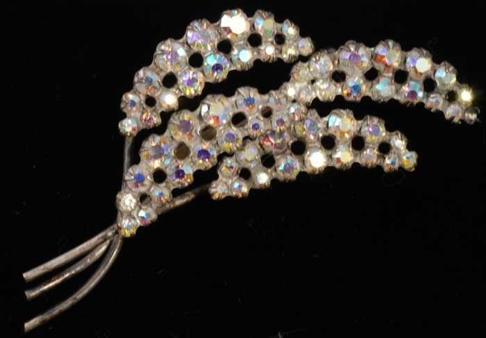 Broche van zilverkleurig metaal, vier bloem-aren met kunstdiamantjes, kapper Van Vliet