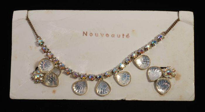 Halsketting (A) en bijbehorend paar oorclips (B-C) beiden met kunstdiamantjes en schelpvormpjes in…