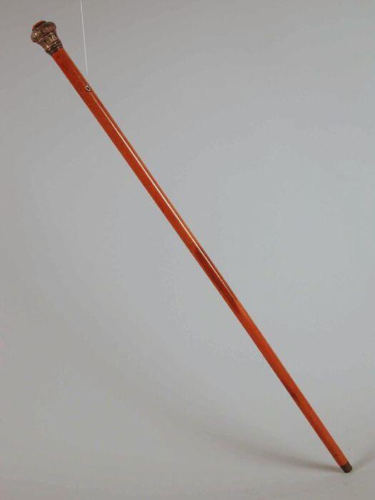 Rechte statiestok met metalen punt en met zilveren knop waarin oranje ingelegde steen, carneool (?)…