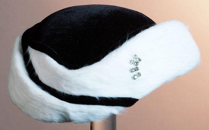 Pillbox met top van zwart velours en rand van wit imitatie-bont en acht strass-steentjes