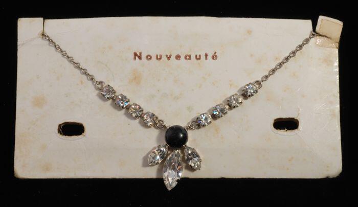 Halsketting met amandelvormige kunstdiamantjes en zwarte ronde steen in een zilverkleurige vattin,…