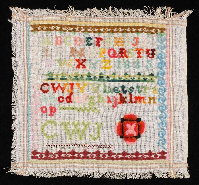Merklap of letterlap gewerkt in kruissteek in gekleurde wol in tapisserie op grof wit katoenen…