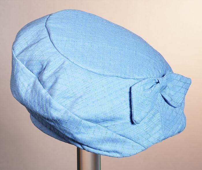 Lichtblauwe baret met strik en sjaal