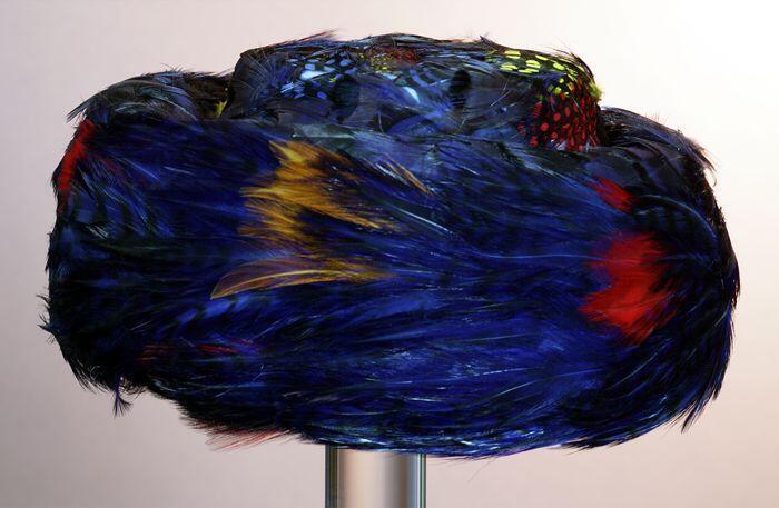 Pillbox van geverfde veren in blauw / zwart / rood / geel / oranje