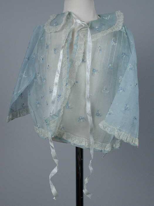 Babyjas (1) en bijpassende muts (2) van transparant blauw organza, geborduurd strooimotiefje in…