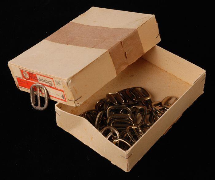 Rechthoekige kleine doos (1) van karton met los deksel (2) waarin 38 koperkleurige metalen gespen …