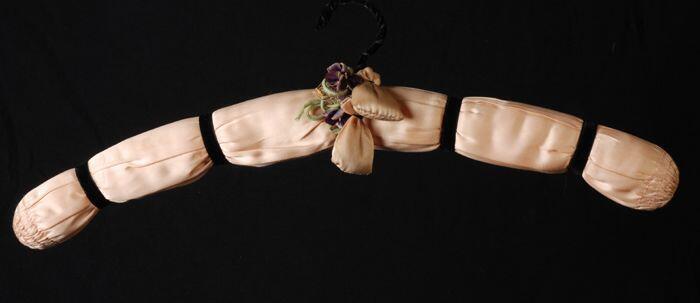 Kledinganger bekleed met roze zijde met zwart fluweelband en paarse fluwelen bloemetjes en twee…