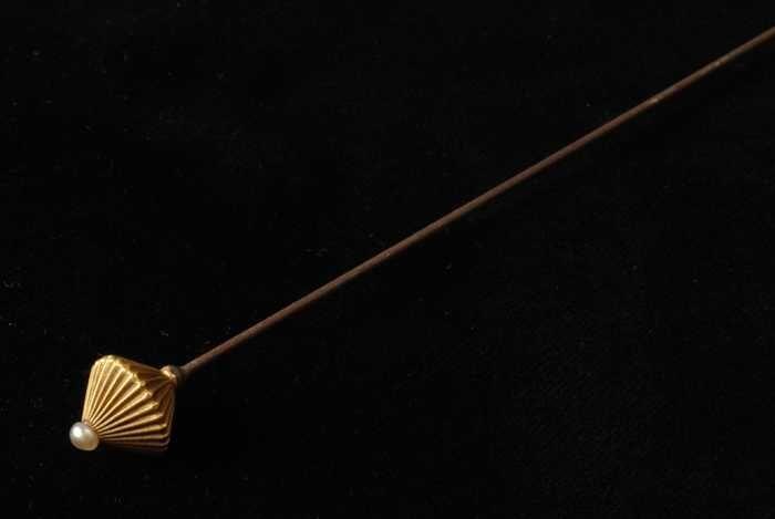 Hoedenspeld, lange metalen pin met scherpe punt, goudkleurige metalen knop, op de top een kleine…