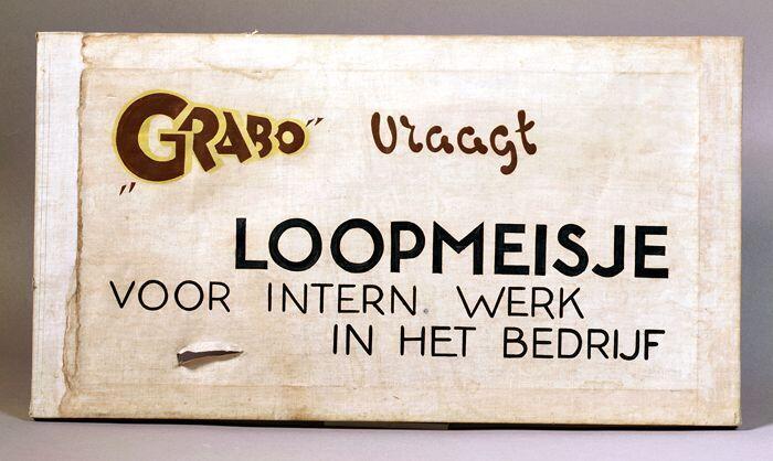 Tekstbord, crèmekleurig stof gespannen over houten raam met opgeschilderde tekst, ""GRABO" vraagt /…