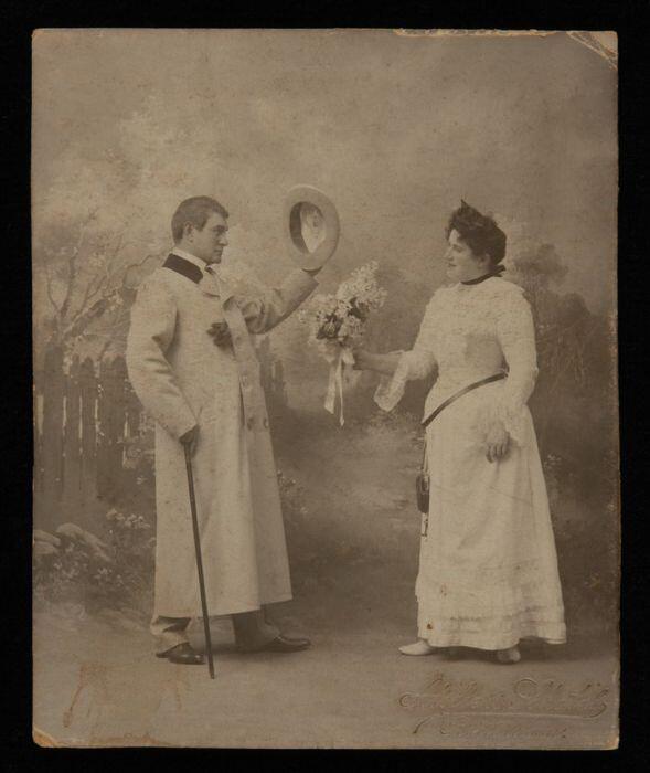 Foto van actrice Marie van Eysden-Vink; heer met hoed begroet dame met bloemen