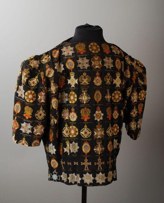 Blouse met korte mouw, patchwork van zijdjes, zwarte stoffen etiketten met kleurige ridderorden