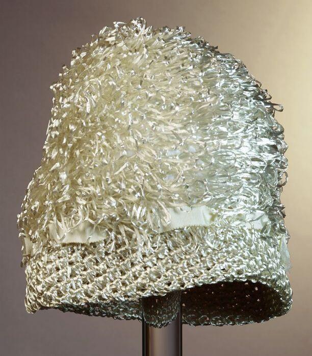 Cloche, glanzend cremekleurig raffia gehaakt, lussen op bol en ribslint langs bol geregen