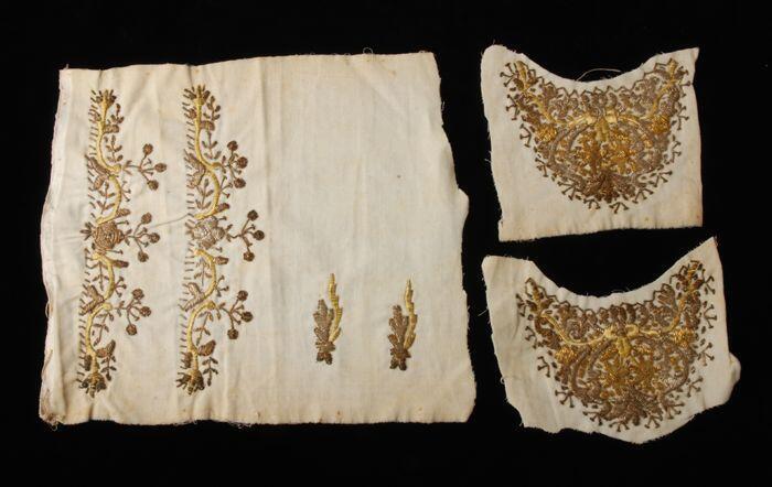 Drie lappen van wit fluweel met gouddraadborduursel in de vorm van schoenvoorblad, hiervan kunnen…