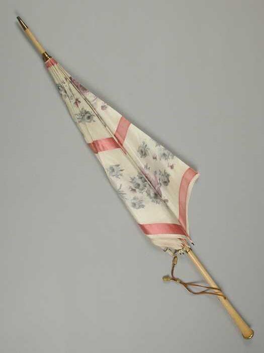 Parasol met bekleding van witte zijdewaarop roze banen en paarse en groene rozen, houten steel met…