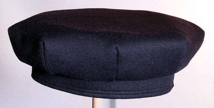 Zwarte baret voor meisjes (?) met ronde ingang en achthoekige bol en gele zijde binnenzijde