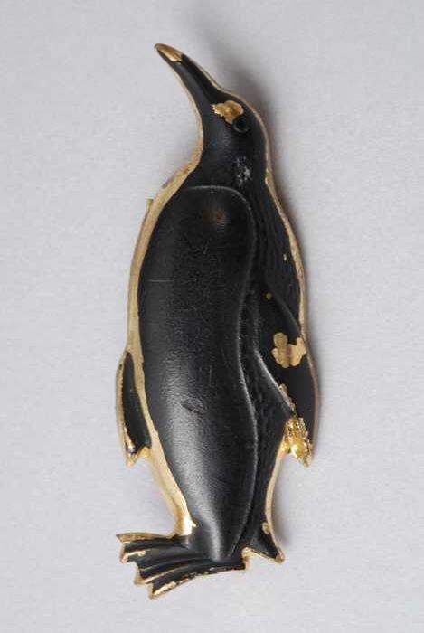 Broche, zwart geschilderde pinguïn van goudkleurig metaal, kapper Van Vliet