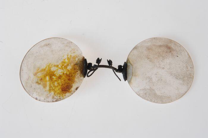 Pince-nez met glazen met verend klemmende neusbrug, uit de brand van 14 mei 1940 afkomstig