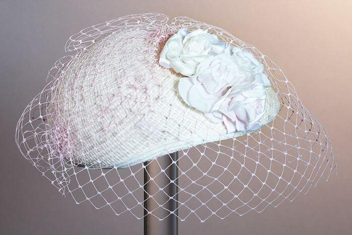Dopje, roze en wit gevlochten raffiawaarover roze voile en garnering van roze rozen van stof