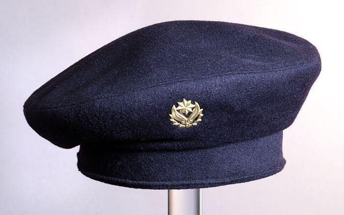 Zwarte unisex kinderbaret met goudkleurig speldje