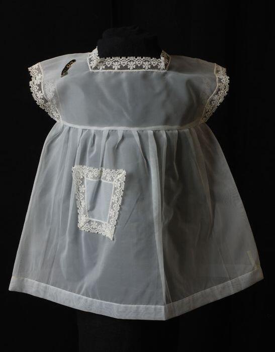 Babyjurk, mouwloos schortmodel van transparant grijs nylonmet wit kantrandje, 'Femifra' model …