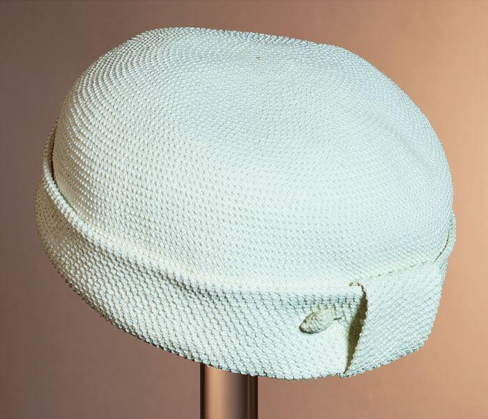 Ronde pillbox van wit gevlochten raffia met metalen hoedenspeld