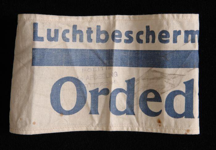Mouwband, wit katoen met opdruk in donkerblauw, "Luchtbeschermingsdienst Ordedienst", twee stempels