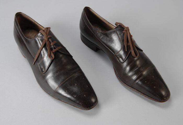 Donkerbruine herenschoen (brogue) met vetersluiting, zeer spitse neus met gaatjesdecoratie, lage hak