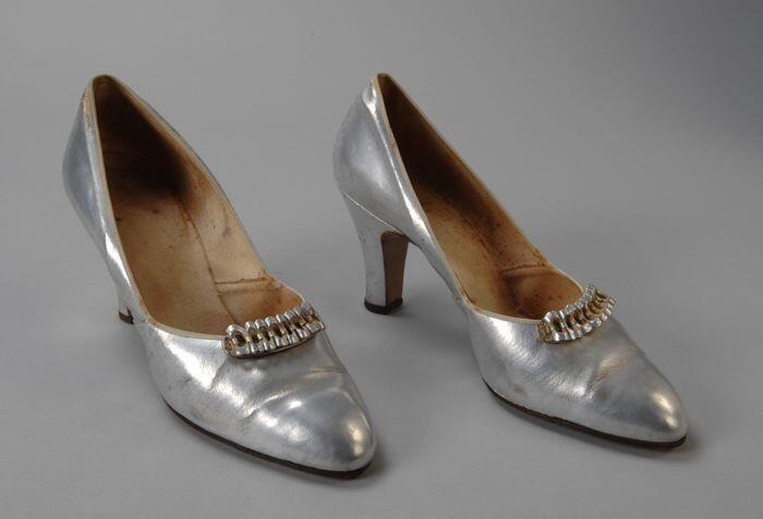 zilverkleurige linnenpumps met hoge hak en siergesp van leren cirkeltjes op de voorvoet,…
