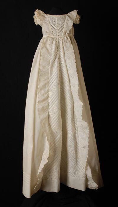 Lange doopjurk van wit katoen met broderie anglaise en middenvoor een lange rij knoopjes