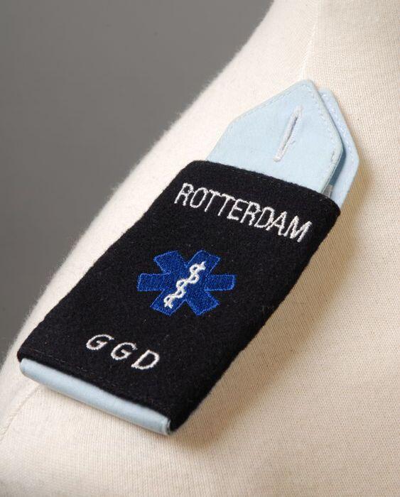 Paar epauletten van uniformhemd waarop embleem "Rotterdam, GGD"