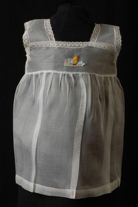 Babyjurk, mouwloos schortmodel van transparant wit nylonmet wit kant en geborduurd kuiken, 'Femifra…