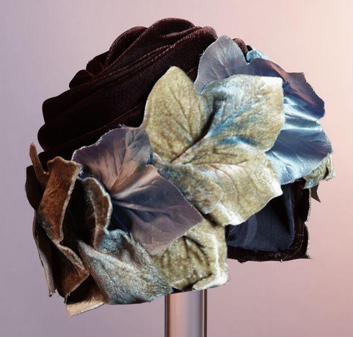 Turban van gedrapeerd donkerbruin velours met rand van beige blauwe bladeren van stof