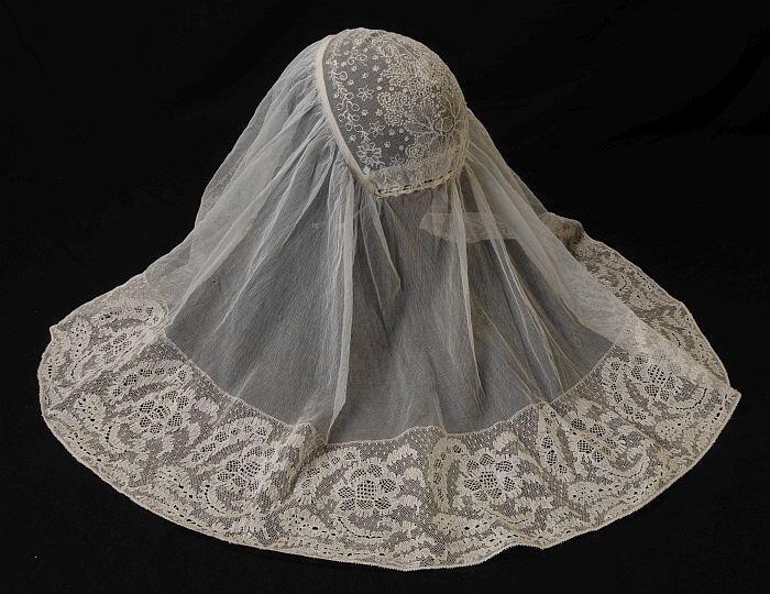 Keuvel (sluiermuts, floddermuts), streekdrachtmuts, bol van tule met wit borduursel, rondom tule en…