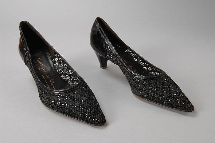 Zwarte pumps met gevlochten voorkant waar strookjes imitatie lakleer door zijn geweven, spitse neus…