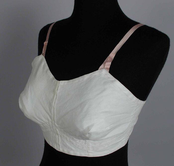Witte bustehouder, roze band binnenzijde roze stiksels, roze schouderbandjes, elastisch bandje met…