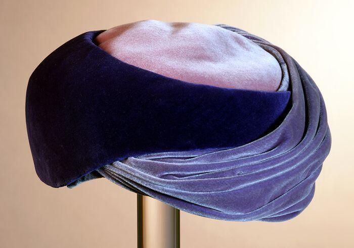 Fluwelen turban met roze top, deels glad donkerpaars en lichtpaars geplooid rondom