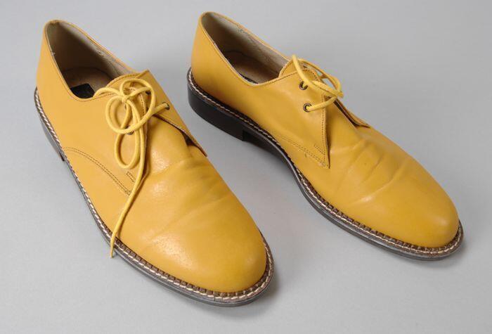 Gele leren herenschoenen met vetersluiting, bruine zool met opvallende witte stiknaad langs de…