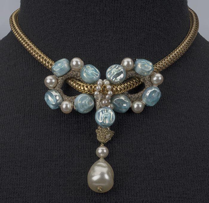 Goudkleurig metalen collier met strik van lamé-koord met imitatieparels